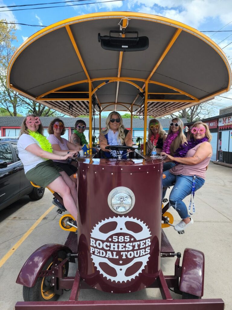Group of ladies enjoying a birthday celebration party on a pedal pub wearing matching sunglasses