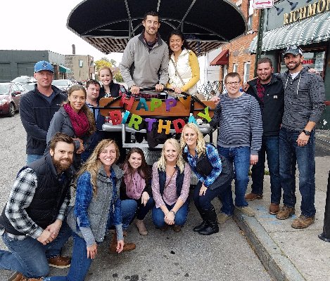 Group of people posing in front of a pedal pub while celebrating a 21st birthday