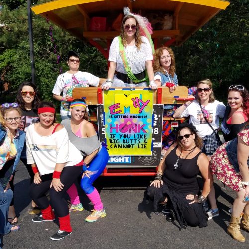 group of ladies posing in front of a pedal pub celebrating their friend getting married