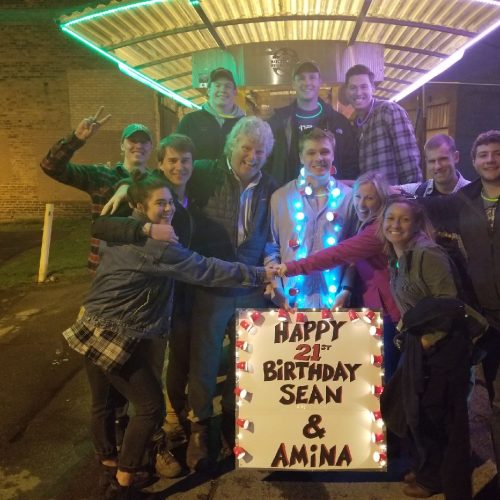 family and friends celebrating a 21st birthday on a pedal pub smiling and posing for a memorable picture